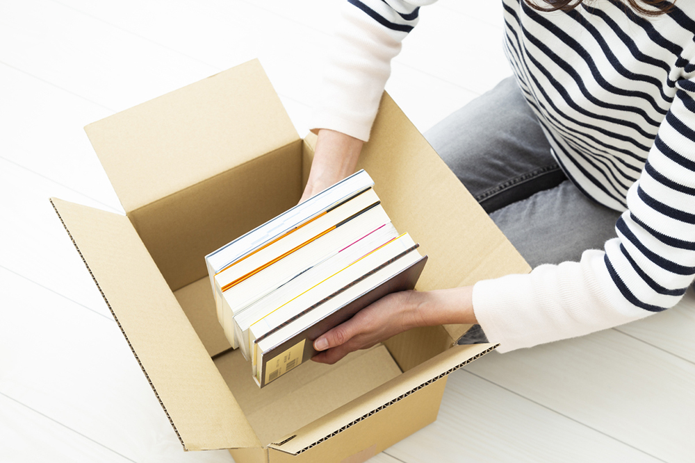 Interlibrary Loan: A woman puts books into boxes to mail.