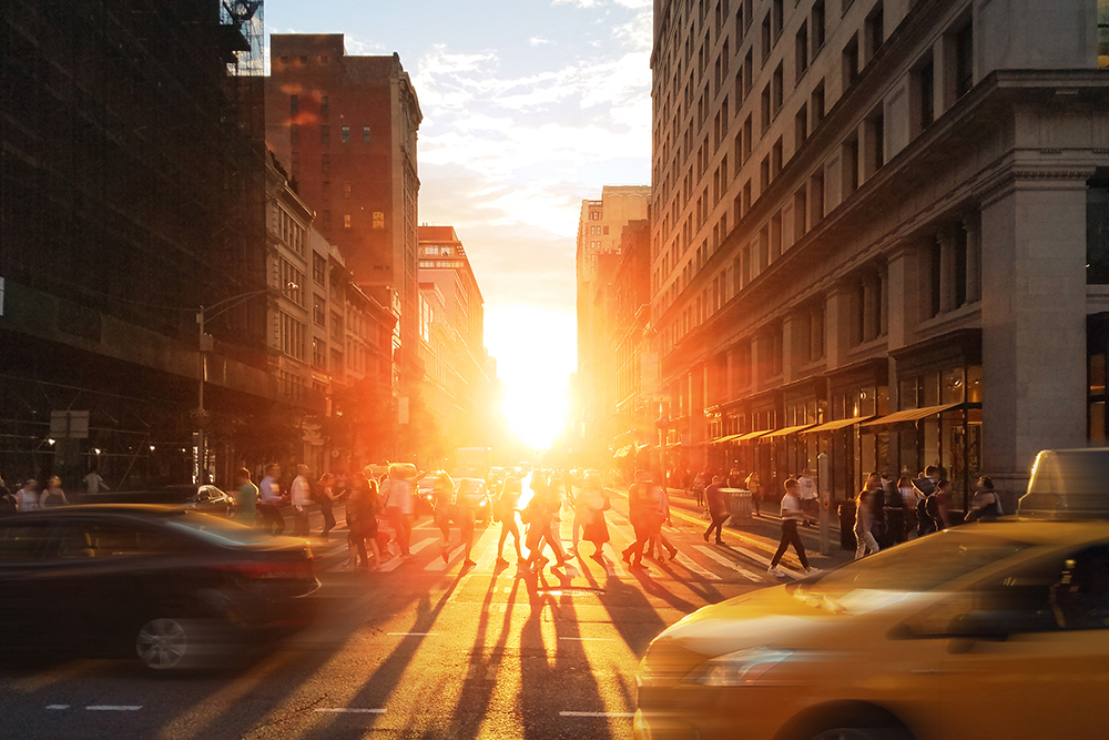 Crowds of people and cars in the busy intersection on 23rd street and 5th avenue in New York City.