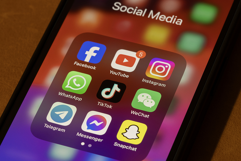 Some of the most popular social media apps by number of monthly active users, including Facebook, YouTube, Instagram, WhatsApp, TikTok, WeChat, Telegram, Messenger, and Snapchat, are seen on an iPhone.