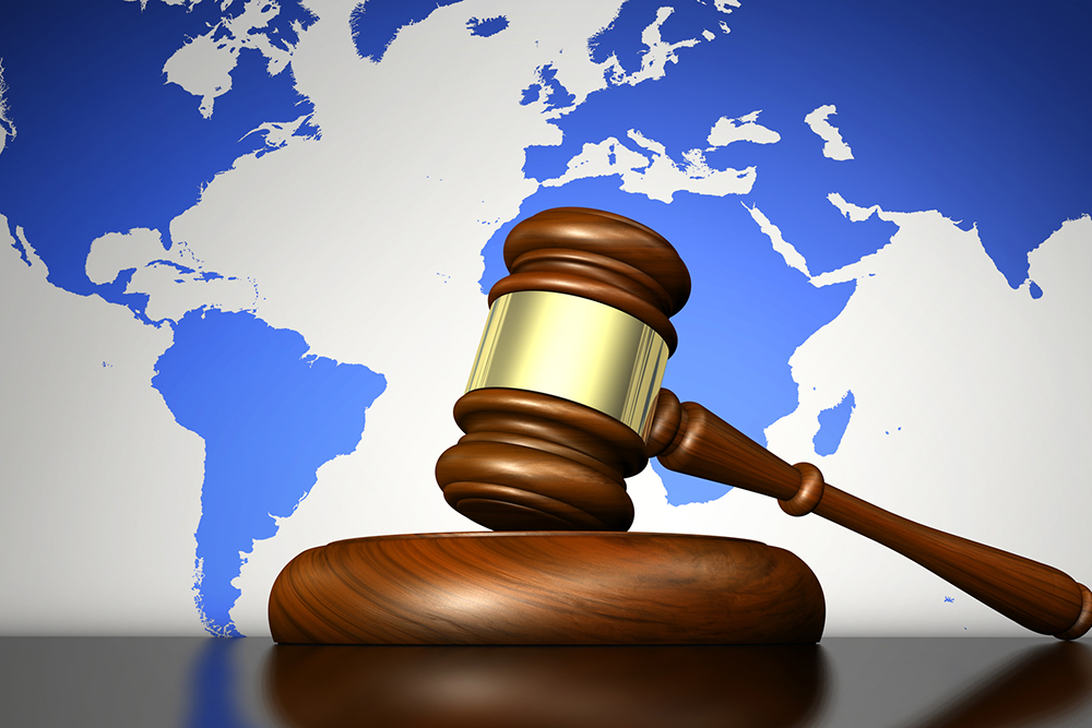 International Law: International law system, justice, human rights and global business concept with a gavel and world map on background.