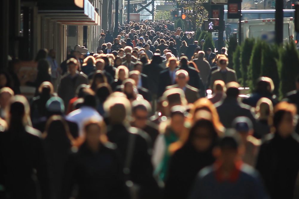 Urban Sociology: Image of people walking down major, large city street.
