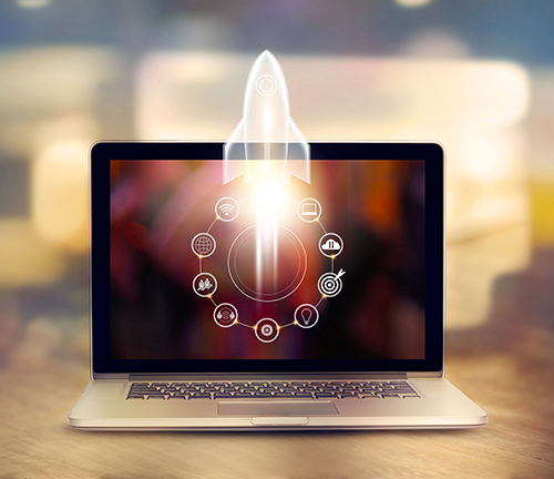 Startup concept. Laptop on wooden table and and icon network connection with rocket icon flying out of screen